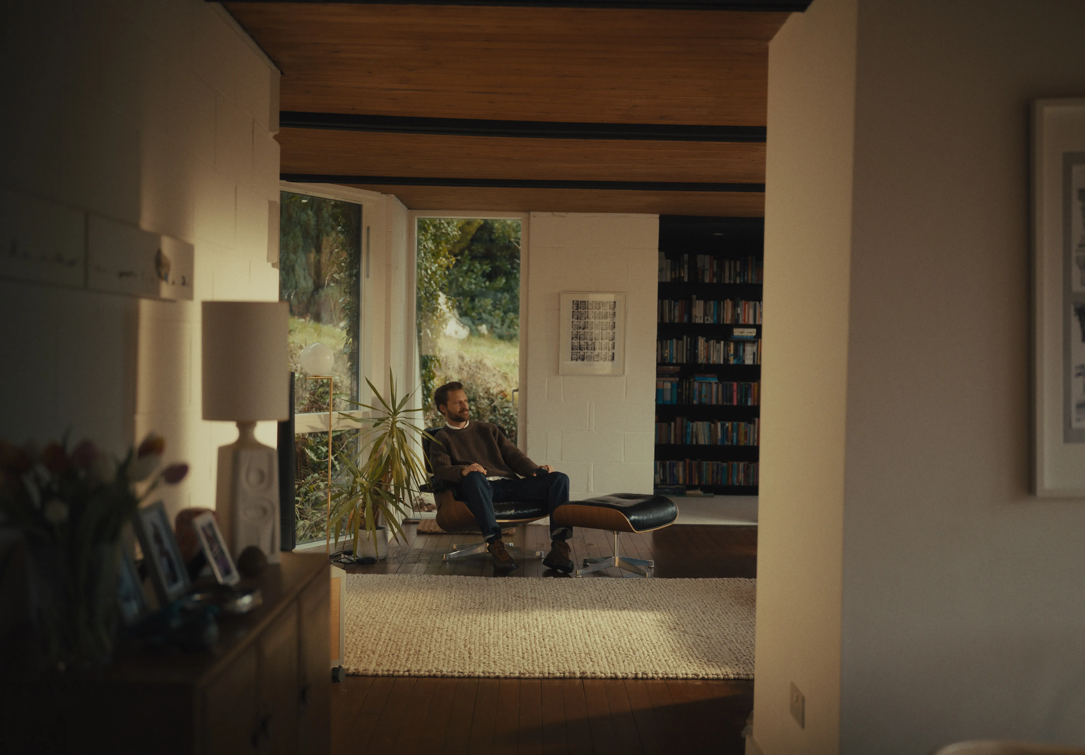 A person enjoying a moment of calm in a modern home, representing the long-term peace of mind provided by smart wealth management.