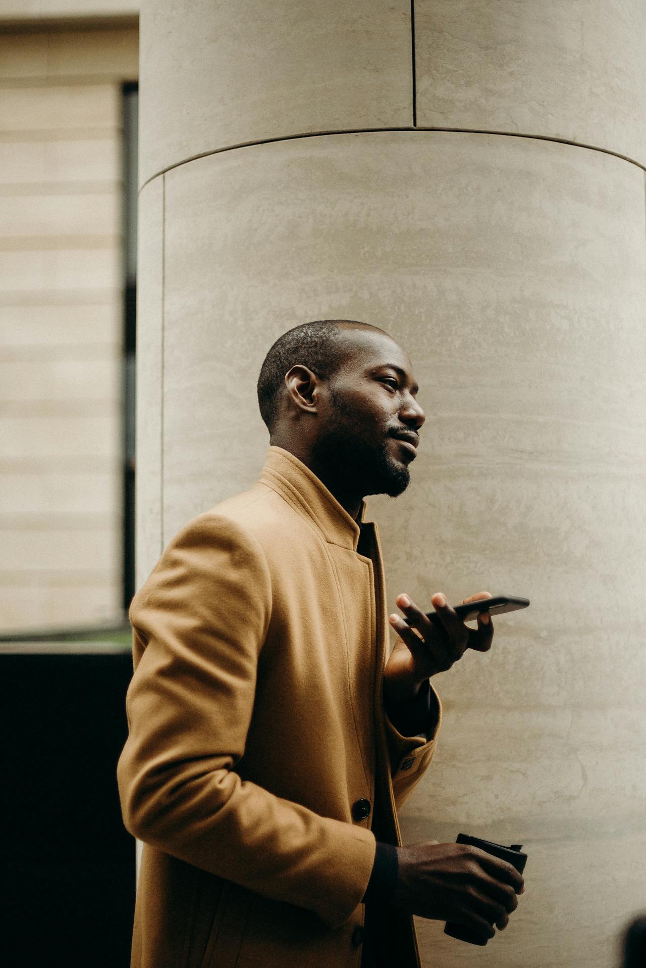 Man looking thoughtfully out of a window in a modern apartment with soft natural light
